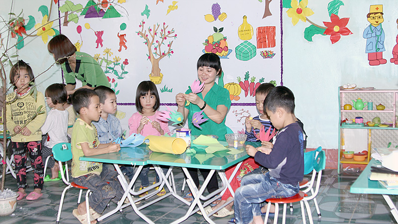 Cô Nguyễn Thị Tới hướng dẫn các con làm hoa trang trí lớp.